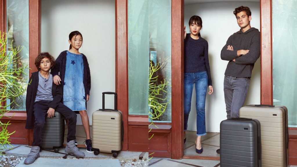 a man and woman standing in front of a door with luggage