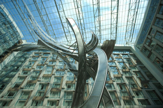 a sculpture in front of a glass roof