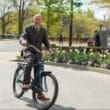 a man in a suit riding a bicycle