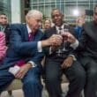 a group of men sitting and holding wine glasses