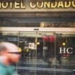 a blurry image of a man walking in front of a hotel