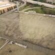 a large concrete building with a lot of cars and a highway