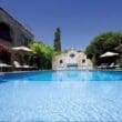 a swimming pool with a stone building in the background