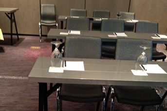 a table with chairs and a glass of water