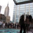a group of people standing around a pool