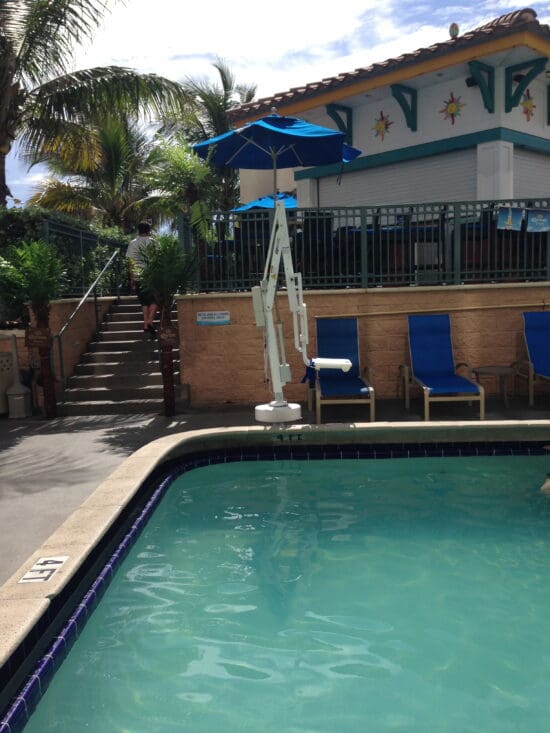 a pool with a umbrella and a person in the back