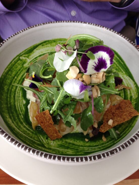 a salad with flowers and nuts in a bowl