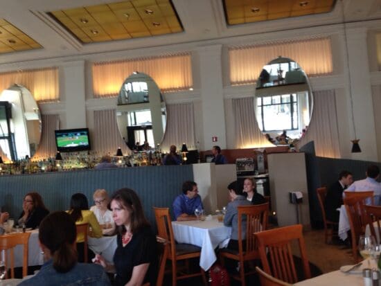 a group of people sitting at tables in a restaurant