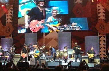 a group of people on a stage with a large screen