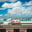 a woman lying on a lounge chair by a pool