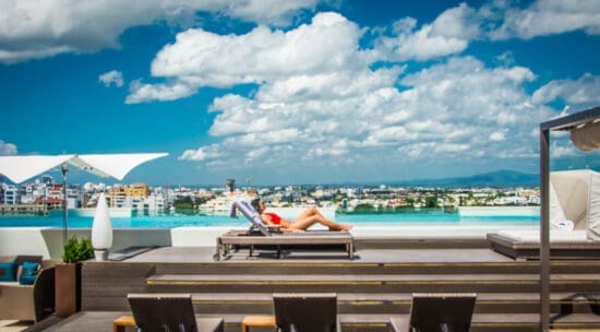 a woman lying on a lounge chair by a pool