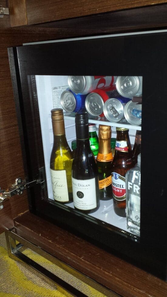 a glass cabinet with bottles and cans