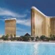 a large pool with tall buildings with Mandalay Bay in the background