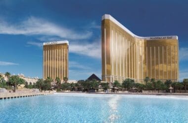 a large pool with tall buildings with Mandalay Bay in the background