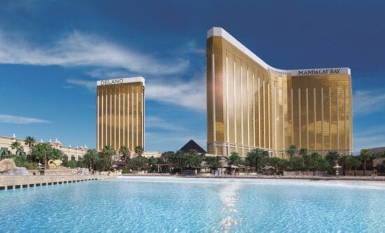 a large pool with tall buildings with Mandalay Bay in the background