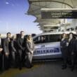 a group of people standing next to a car