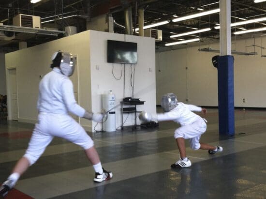 two people in fencing gear