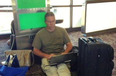 a man sitting on the floor with his laptop