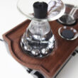 a glass container with a metal object on top