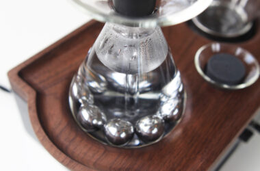 a glass container with a metal object on top