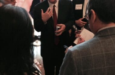 a man in a suit standing in front of a group of people