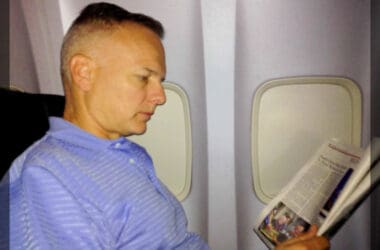 a man reading a newspaper on an airplane