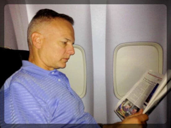 a man reading a newspaper on an airplane