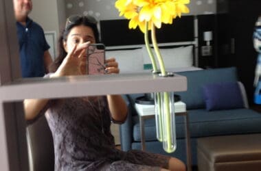 a woman taking a selfie with a yellow flower