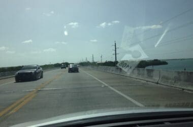 cars on a road with a sign on it