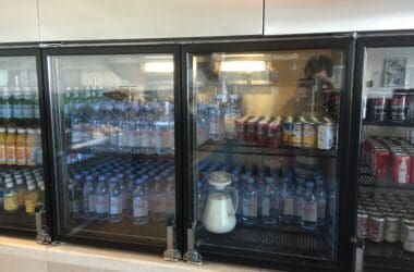 a refrigerator with bottles of water and cans of soda