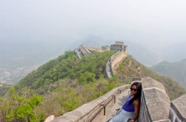 a woman sitting on a stone wall