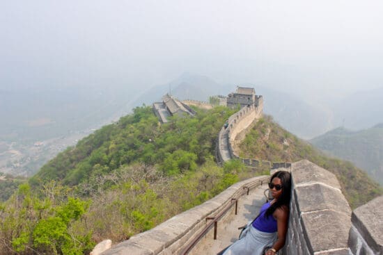 a woman sitting on a stone wall