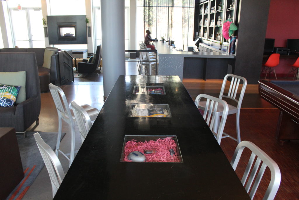 A communal table in a hotel lobby at the Aloft Las Colinas