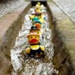 a row of rubber ducks in a canal