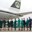 a group of people in uniform standing in front of an airplane