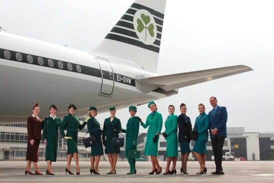 a group of people in uniform standing in front of an airplane