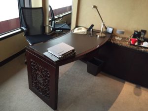 a desk with a lamp and a telephone on it