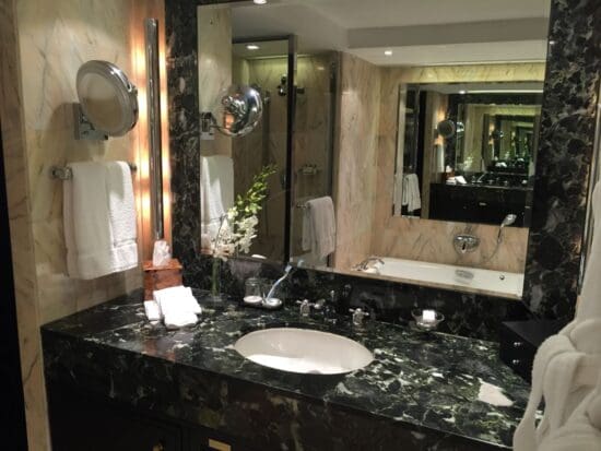 a bathroom with a marble countertop and a large mirror