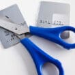 a pair of scissors with blue handles and a credit card