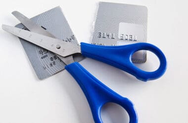 a pair of scissors with blue handles and a credit card