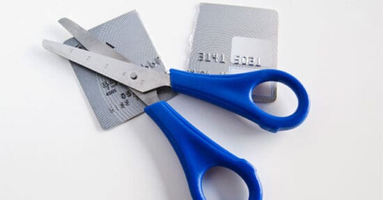 a pair of scissors with blue handles and a credit card