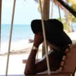 a woman sitting in a chair on a beach