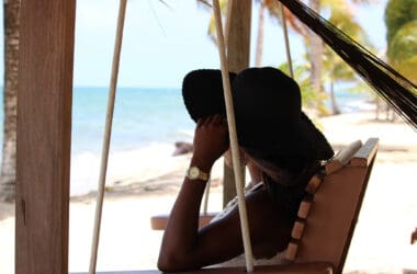 a woman sitting in a chair on a beach