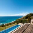 a deck with a pool overlooking the ocean