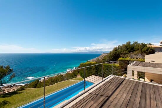 a deck with a pool overlooking the ocean