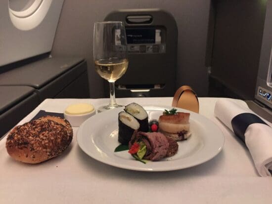 a plate of food and a glass of wine on a table