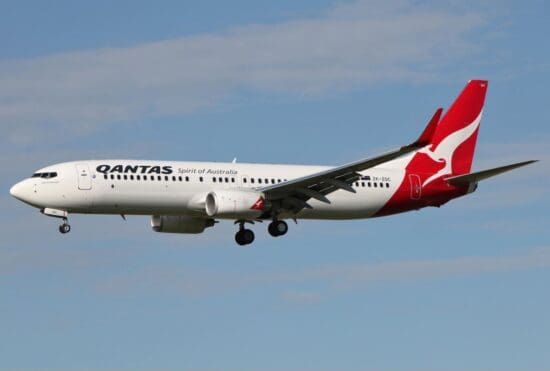 a white and red airplane flying in the sky