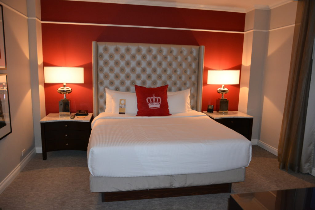 a bed with a red headboard and a lamp on the side