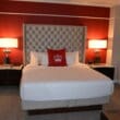 a bed with a red headboard and a lamp on the side