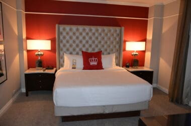 a bed with a red headboard and a lamp on the side